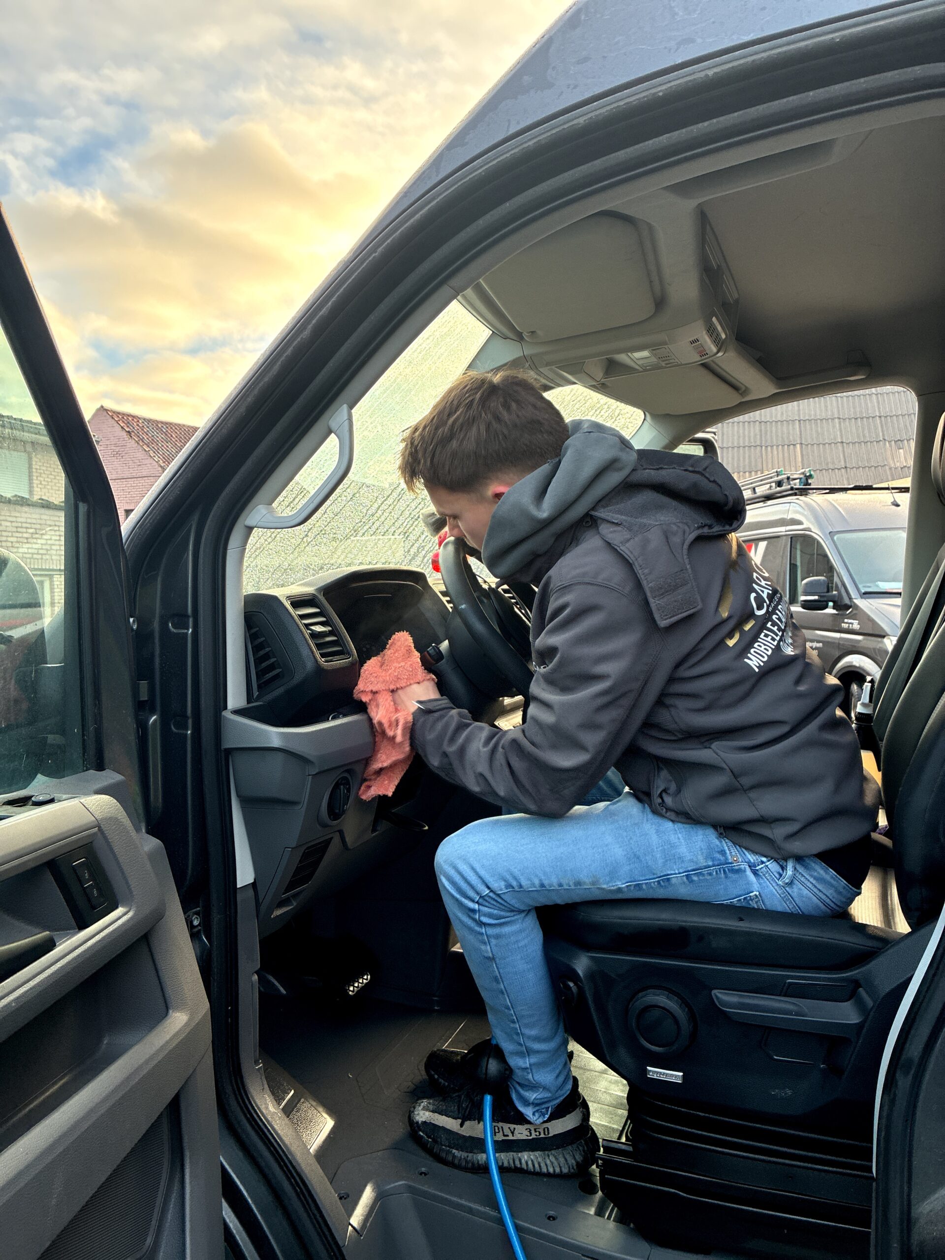 Interieur dieptereiniging van bedrijfswagen met zichtbare vervuiling aan instap, vloer en zetel in Harelbeke